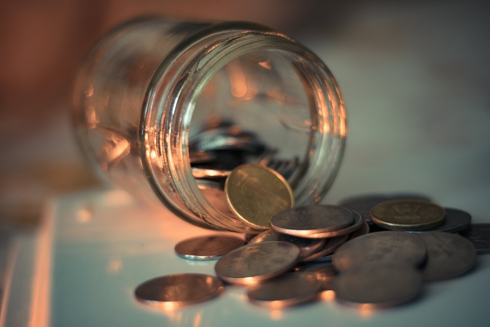 Tipped-over jar with spilled coins